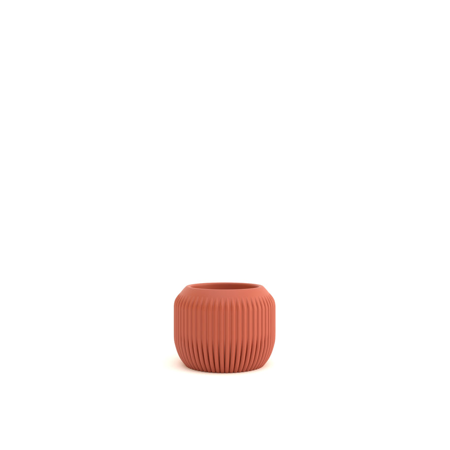 Terracotta-colored ribbed pot on a white background