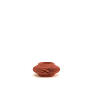 Terracotta vase with textured surface on a white background