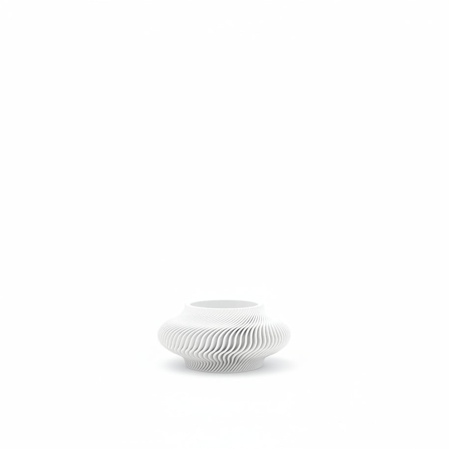 White ceramic vase with wavy design on a white background