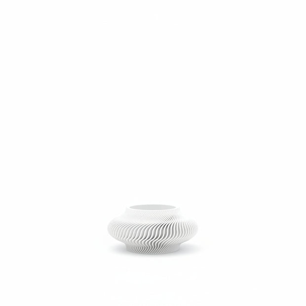 White ceramic vase with wavy design on a white background